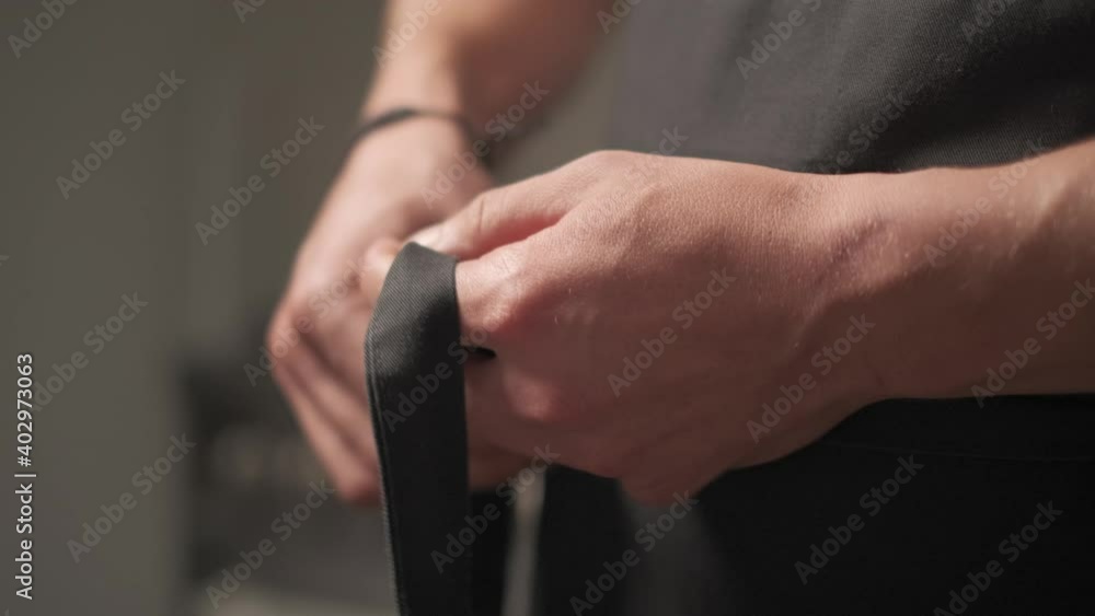Slow motion shot: Men's hands tie a belt on a black jacket. 4k Slow motion shot: Men's hands tie a belt on a black jacket. 4k