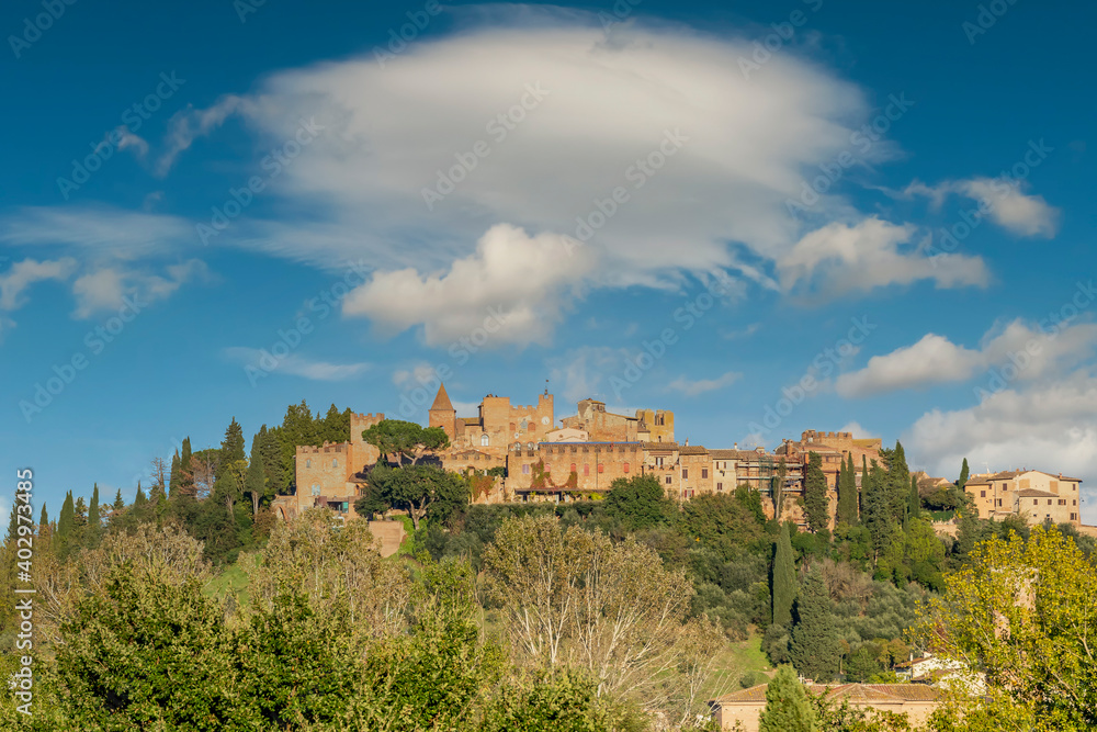 Panoramic view of the historic center of Certaldo alto lit by the late afternoon sun, against a beautiful sky, Tuscany, Italy