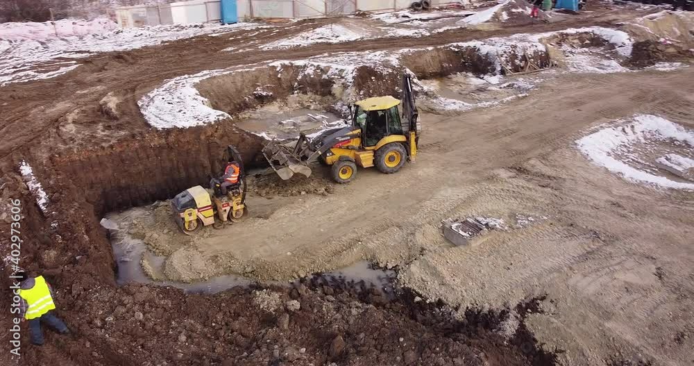 Aerial view of heavy machinery, tractor transporting land, construction preparation. The skating rink compacts the ground. Start of construction of the building flick. Aerial view of heavy machinery, tractor transporting land, construction preparation. The skating rink compacts the ground. Start of construction of the building flick.