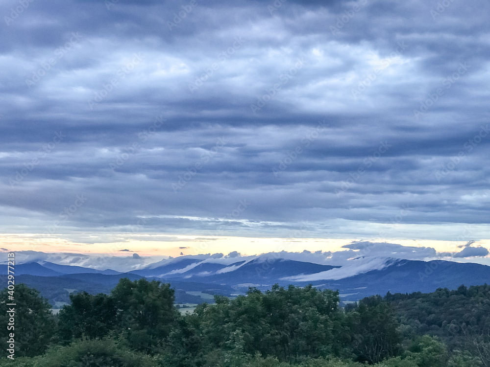 The landscape of the Beskydy Mountains from the viewpoint near Jicin during a rainy afternoon full of dark clouds in the sky and a view of the surrounding landscape. The landscape of the Beskydy Mountains from the viewpoint near Jicin during a rainy afternoon full of dark clouds in the sky and a view of the surrounding landscape.