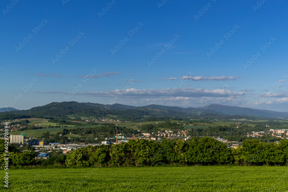 Obraz premium Views of the hills and surrounding city with views of the surrounding hills in the background of a blue sky with white clouds.
