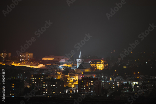 View of the dominant church in the middle of the town of Valasske Mezirici during the night the church is illuminated in yellow.