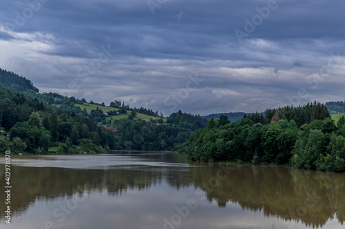 Water level of the Bystricka reservoir during a rainy afternoon with dark clouds in the sky.