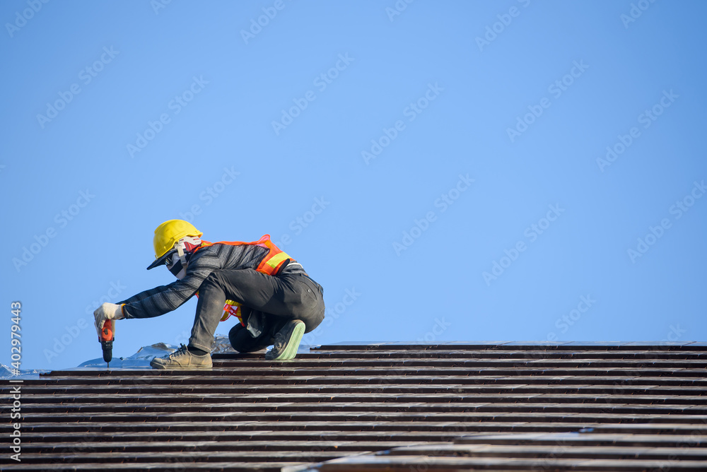 Roof installer Are installing the roof of the house that is Ceramic tile roof at construction site