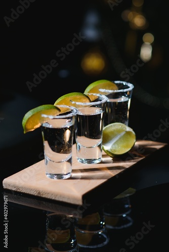 Tequila with lime and salt on black background