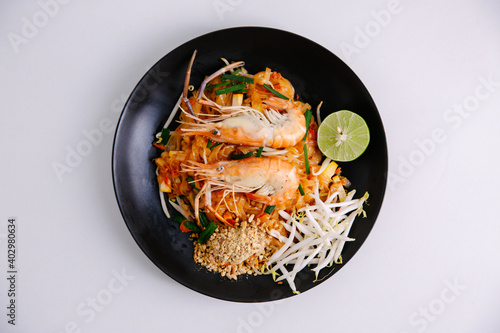 Udon noodle pad thai with shrimp in black plate white background top view asian food Copy space