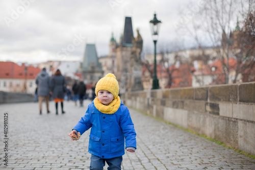 Cute child, boy with family, having a walk in Prague on Charles bridge © Tomsickova