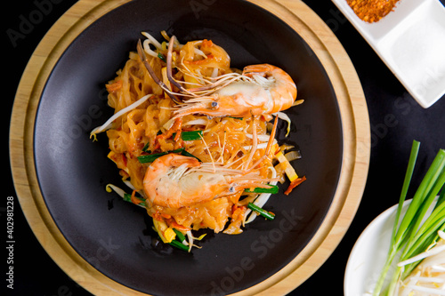 Udon Pad Thai with shrimp in a dark background, top view Asian style food Copy space