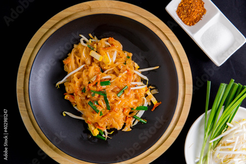 Udon noodles, pad thai, vegetarian vegetables on black plate, top view Asian Vegetarian Copy space