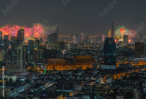 Colorful Firework with cityscape night light view of Bangkok skyline at twilight time. New Year celebration fireworks light up to sky at New Year festival with Copy space. No focus, specifically.