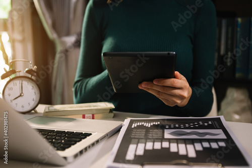 businessman working with digital tablet computer and smart phone with financial business strategy layer effect on desk in morning light.