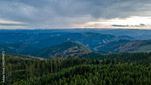 Aerial view of the top of Lysa hill and its surroundings full of trees and views of the surrounding mountains during sunset. © Lukas