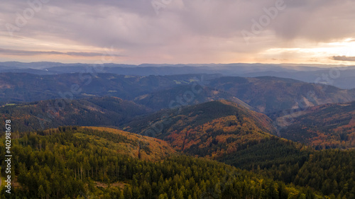 Aerial view of the top of Lysa hill and its surroundings full of trees and views of the surrounding mountains during sunset.