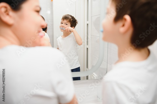 cute mother teaching kid boy teeth brushing