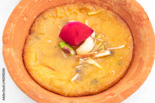 Detailed Close Up Of Famous Indian Dessert Mawa Malpua Mithai Soaked In Sugar Syrup Cheeni Ki Chashni or Chaashni Topped With ry Fruits Pista Badam Kesar Kaju Served In Eco Friendly Terracotta Pot photo