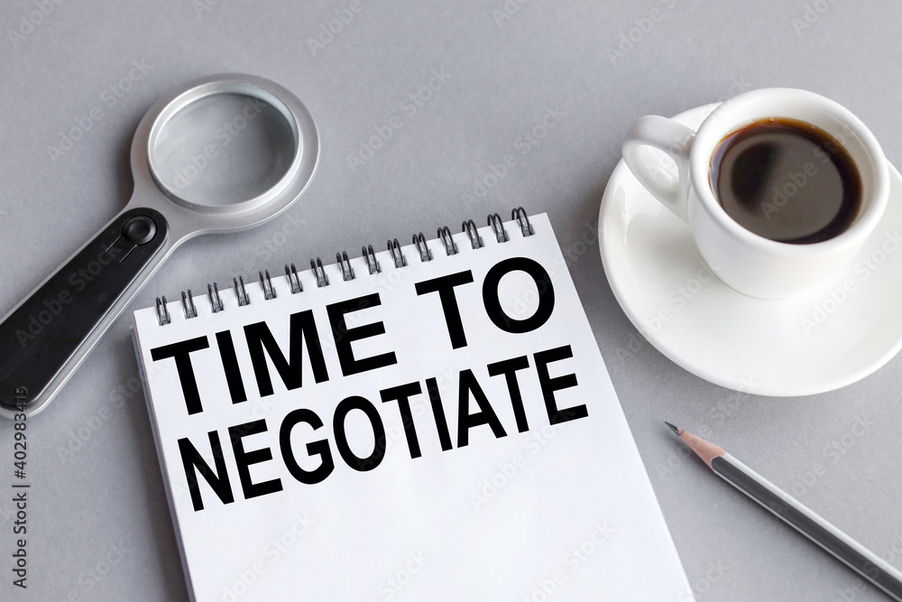 TIME TO NEGOTIATE, text on white notepad paper on gray background. business concept. view from above TIME TO NEGOTIATE, text on white notepad paper on gray background. business concept. view from above