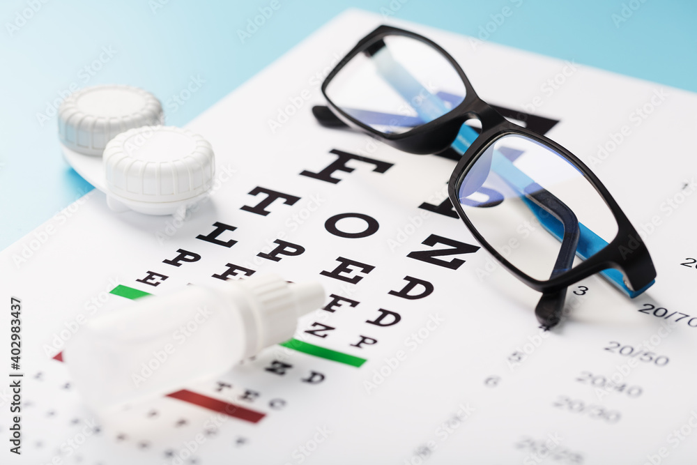 Vision checks and prevention, glasses, lenses and drops for vision correction on a blue background Vision checks and prevention, glasses, lenses and drops for vision correction on a blue background