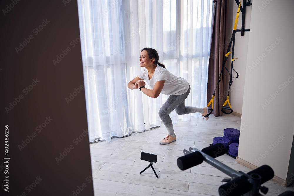 Video blogger demonstrating a strength training exercise to her audience Video blogger demonstrating a strength training exercise to her audience