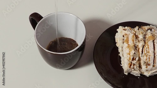 Slice piece of vanilla cake topping with white chocolate chips for coffee or tea break, on white with almond petals, coconut flakes, takes it out of the box, puts it on a saucer, eats, pours coffee