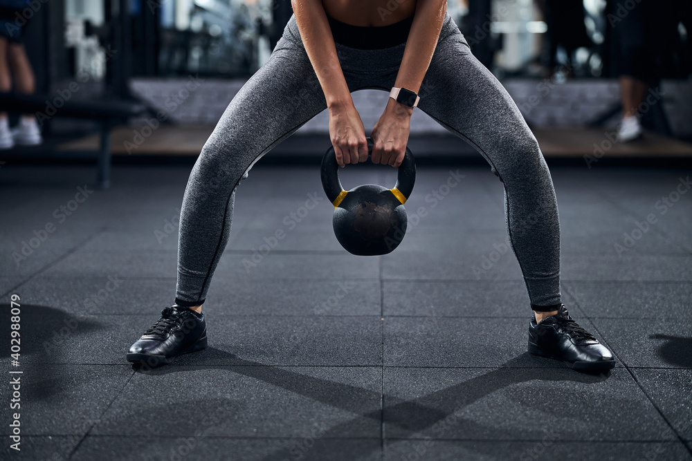 Person with kettlebell doing a sumo squat Stock Photo