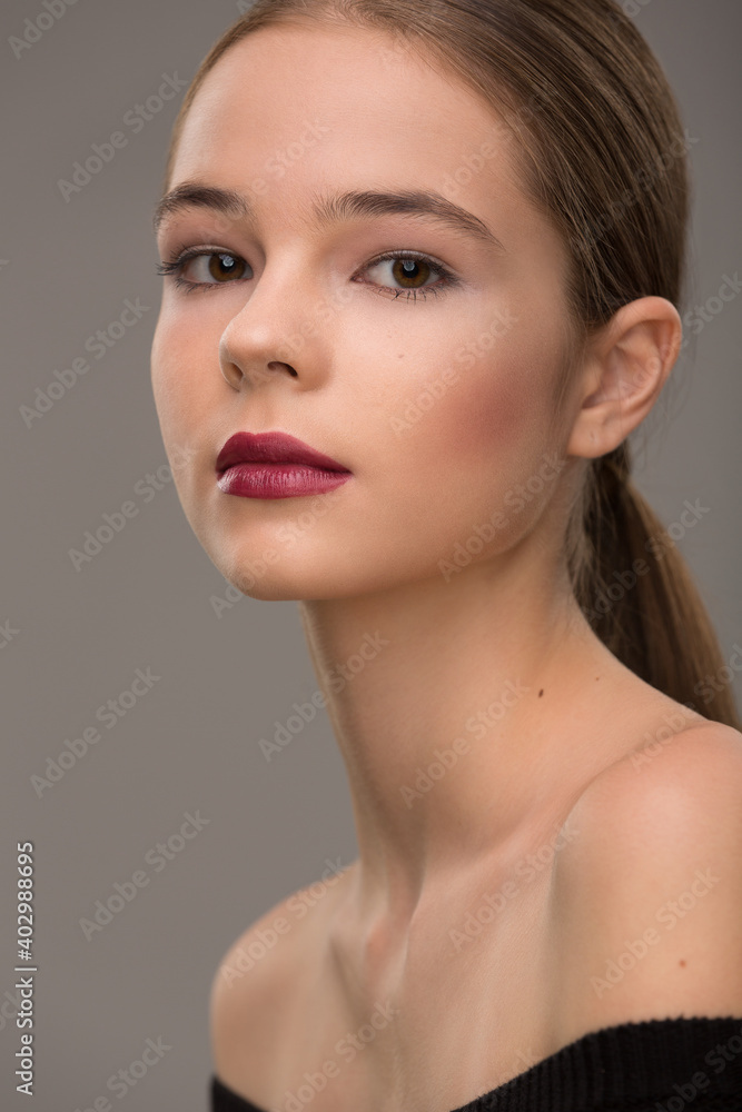 portrait of a beautiful teen girl with exquisite makeup with red lipstick on a gray background portrait of a beautiful teen girl with exquisite makeup with red lipstick on a gray background