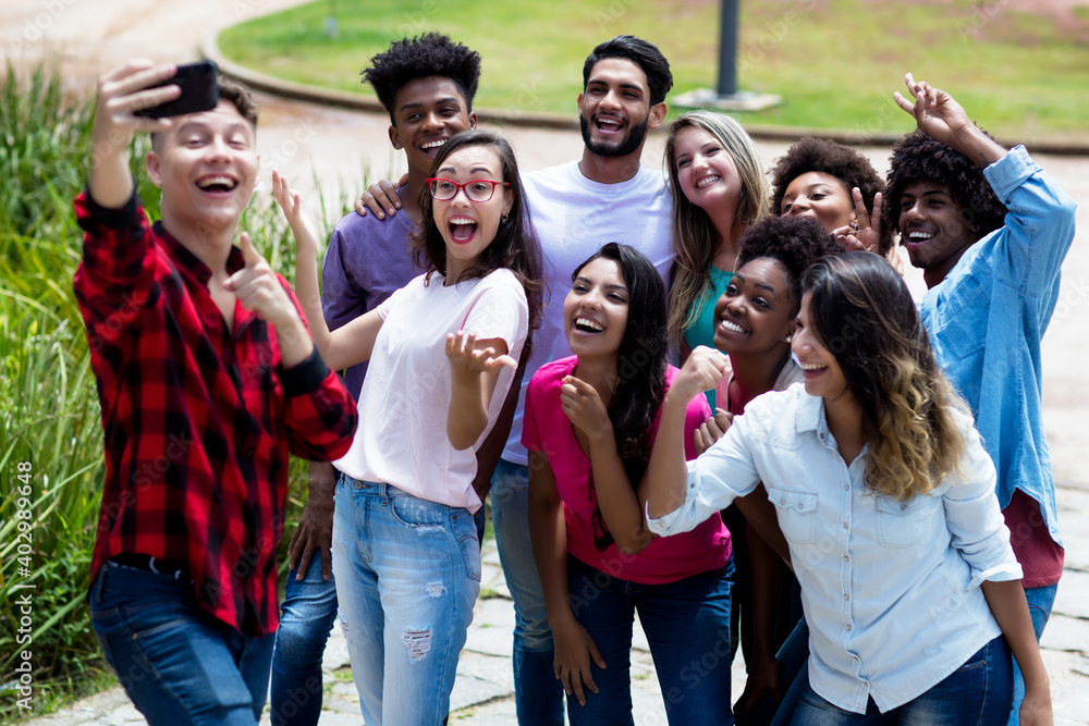 Fototapeta premium Large group of funny multi ethnic young adults taking crazy selfie with phone
