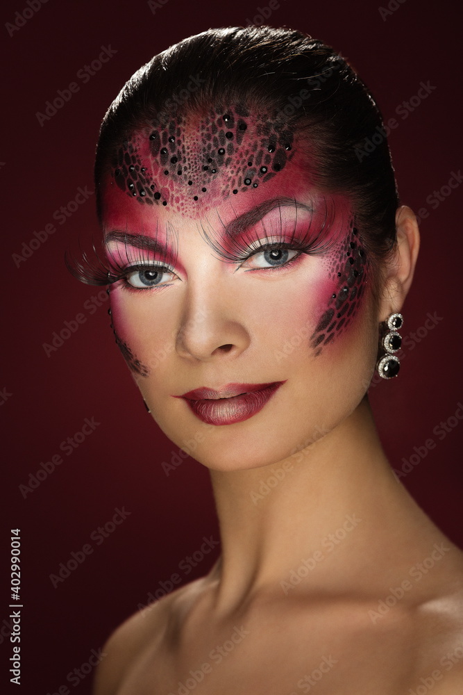 portrait of a beautiful brunette girl with fantasy makeup with elements of body art on a dark red background portrait of a beautiful brunette girl with fantasy makeup with elements of body art on a dark red background