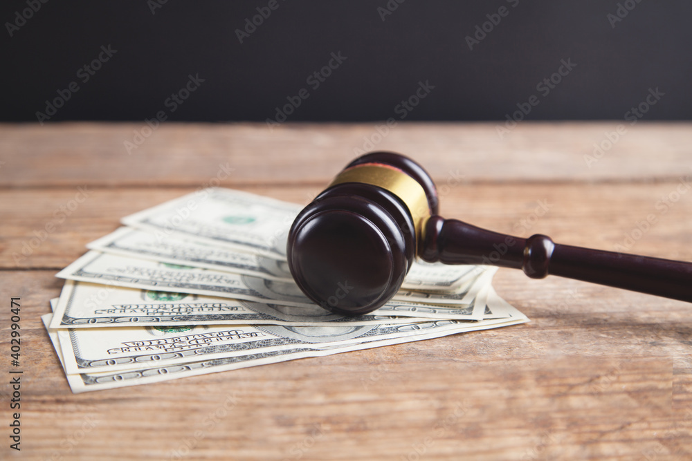 Judge gavel and money on brown wooden table.