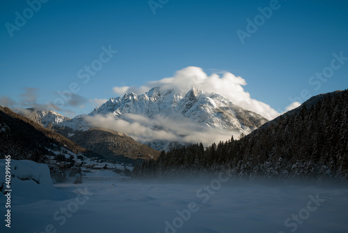 le nuvole sulla montagna in inverno  la luce che filtra le nuvole attorno una montagna innevata  lo splendido panorama invernale sulle dolomiti