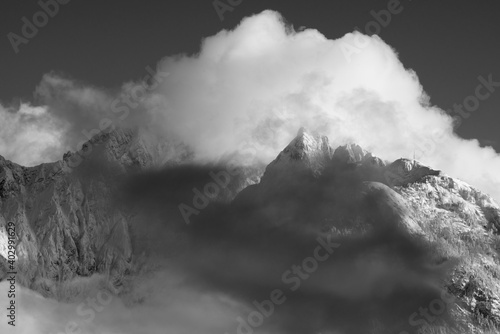 le nuvole sulla montagna in inverno, la luce che filtra le nuvole attorno una montagna innevata, lo splendido panorama invernale sulle dolomiti