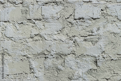 Wall of white inhomogeneous yellow brick. Light shabby texture