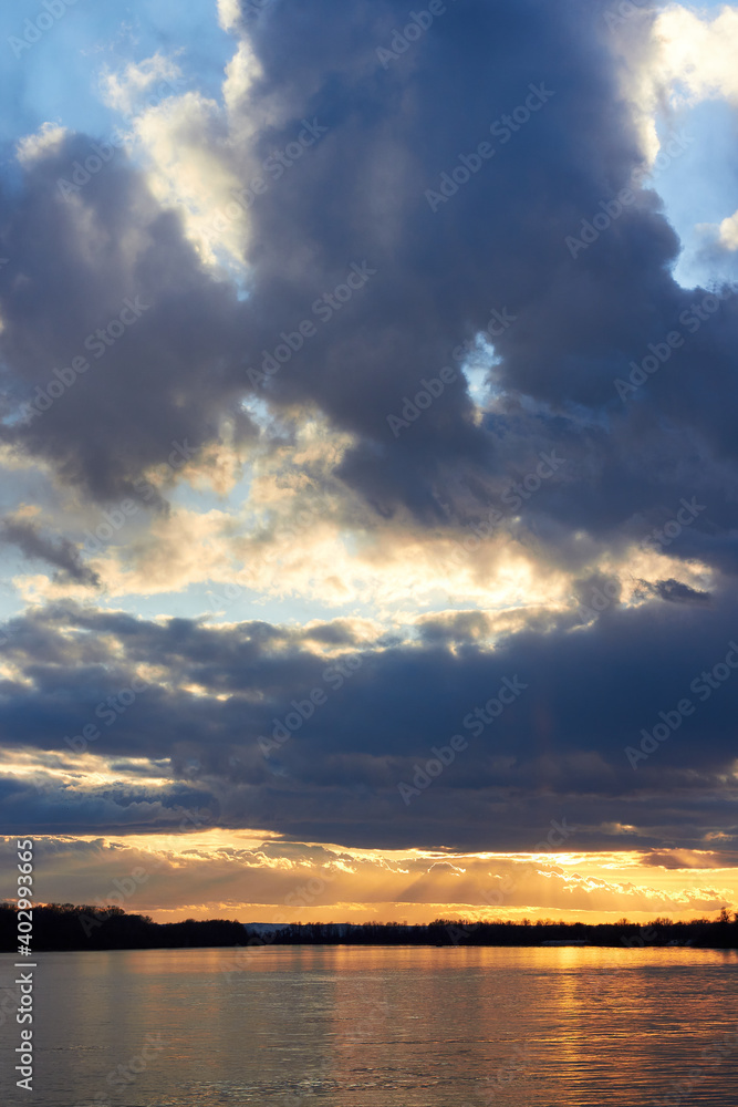 Dramatic sunset cloudy sky over the river at winter season Dramatic sunset cloudy sky over the river at winter season
