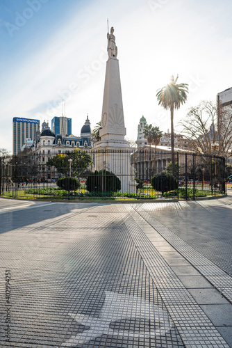 Plaza de Mayo square in Buenos Aires, Argentina. It is believed to be the foundational site of the city. The May pyramid is lit by sunrays, mothers of plaza de mayo's symbol on the ground photo