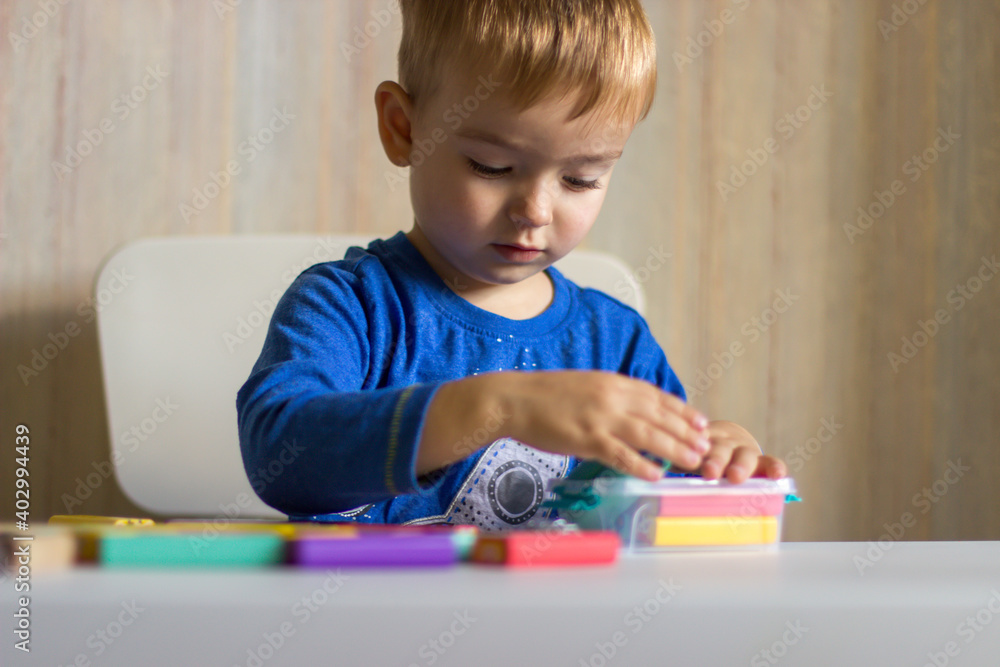 Little boy playing in colored wooden bars Little boy playing in colored wooden bars