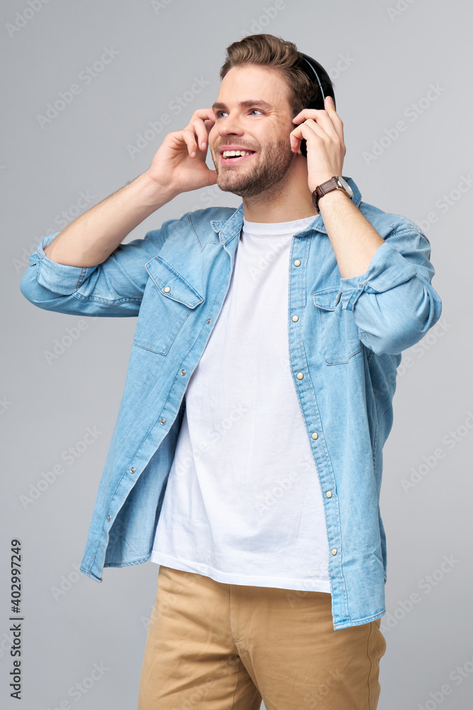 Close up portrait of cheerful young man enjoying listening to music wearing casual jeans outfit Close up portrait of cheerful young man enjoying listening to music wearing casual jeans outfit
