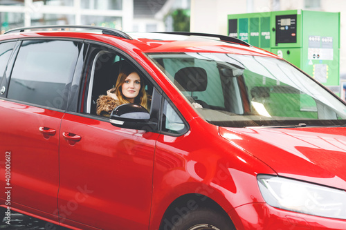 Young attractive woman with happy positive expression, being satisfied with unforgettable journey by car, sits on driver seat. People, driving, transport concept. Winter ski holiday by car