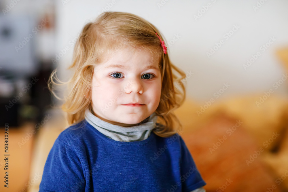 Portrait of adorable cute toddler girl of two years. Beautiful baby with blond hairs looking and smiling at the camera. Happy healthy child at home Portrait of adorable cute toddler girl of two years. Beautiful baby with blond hairs looking and smiling at the camera. Happy healthy child at home