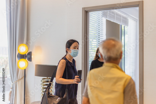 Daughter with senior father wearing face mask looking for new home with real estate.