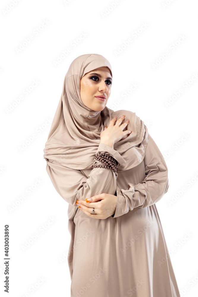 Magazine. Beautiful arab woman posing in stylish hijab isolated on studio background with copyspace for ad. Fashion, beauty, style concept. Female model with trendy make up, manicure and accessories. Magazine. Beautiful arab woman posing in stylish hijab isolated on studio background with copyspace for ad. Fashion, beauty, style concept. Female model with trendy make up, manicure and accessories.