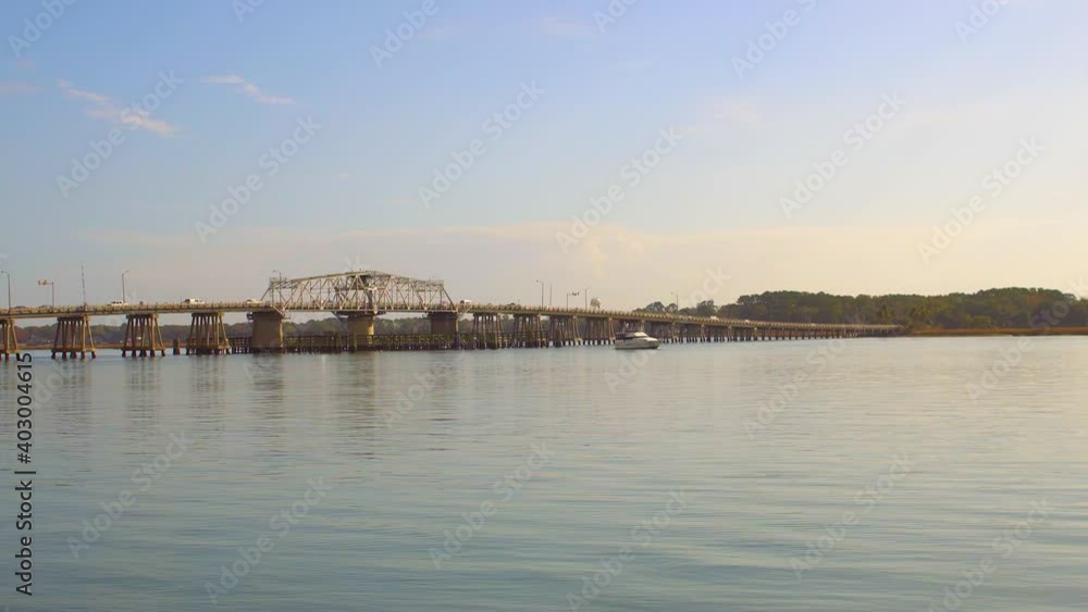 A boat passes under Richard V. woods memorial bridge in beaufort south carolina. A boat passes under Richard V. woods memorial bridge in beaufort south carolina.