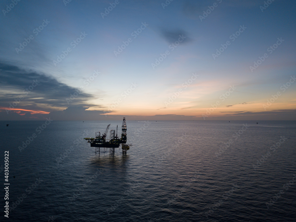 Aerial view offshore drilling rig (jack up rig) at the offshore location during sunset Aerial view offshore drilling rig (jack up rig) at the offshore location during sunset
