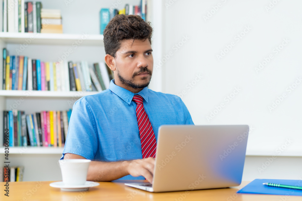 Serious latin american businessman working at computer Serious latin american businessman working at computer