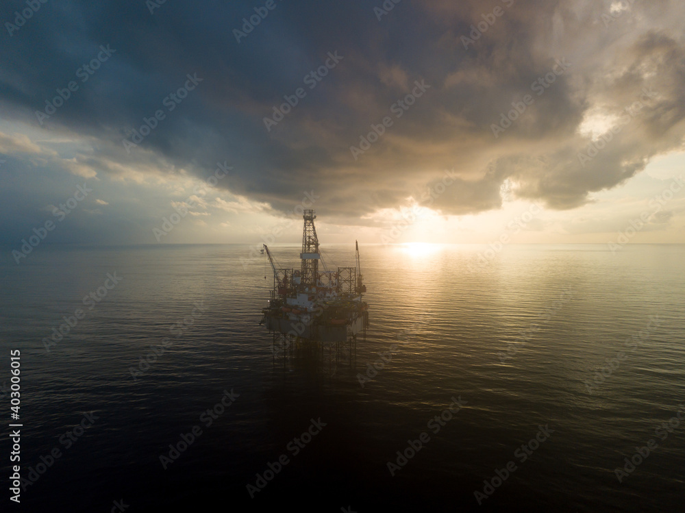 Aerial view offshore drilling rig (jack up rig) at the offshore location during sunrise