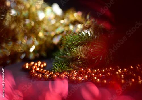 Orange beads with round beads to decorate the Christmas tree  close-up against a background of blurred red light from the lamps. 