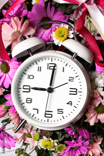 Wallpaper Mural White alarm clock against the background of fresh flowers in a wicker basket. Spring time. Torontodigital.ca