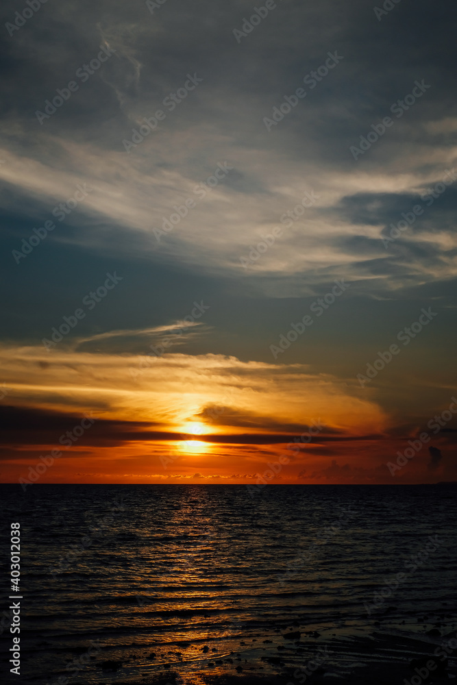 Orange and blue sunset with clouds over the ocean