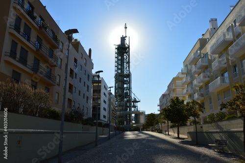 Mysterious industrial tower near the city buildings.
