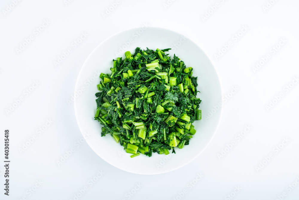 A dish of fried potherb mustard on a white background A dish of fried potherb mustard on a white background