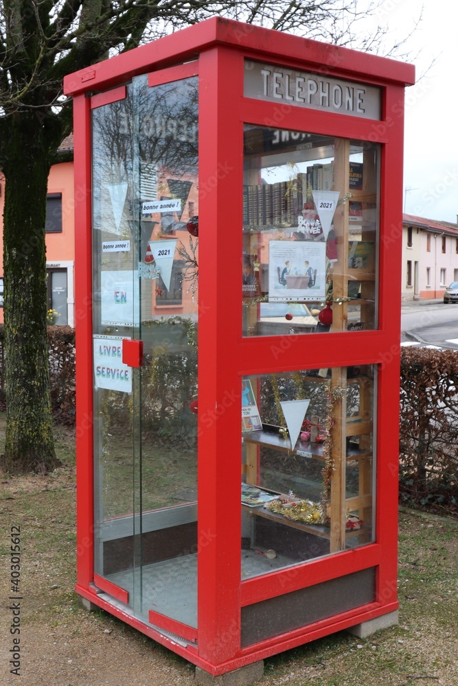 Ancienne cabine téléphonique rouge transformée en point d'échange de livres, ville de Polliat, département de l'Ain, France Ancienne cabine téléphonique rouge transformée en point d'échange de livres, ville de Polliat, département de l'Ain, France