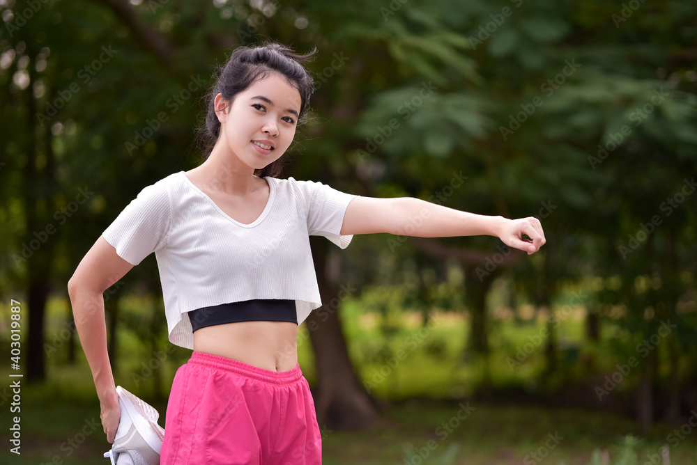 Asian woman is warm up, To make the muscles flexible Before going to jogging for good health and energy metabolism,Outdoors cross training workout. Healthcare concept Asian woman is warm up, To make the muscles flexible Before going to jogging for good health and energy metabolism,Outdoors cross training workout. Healthcare concept